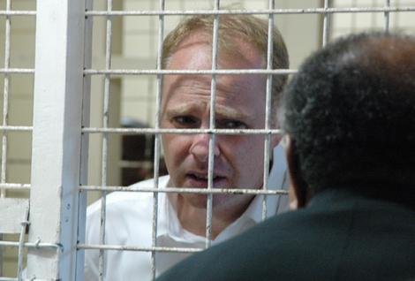 Simon Macartney speaks to his lawyer  from the lockhouse in the Suva Magistrates Court today.