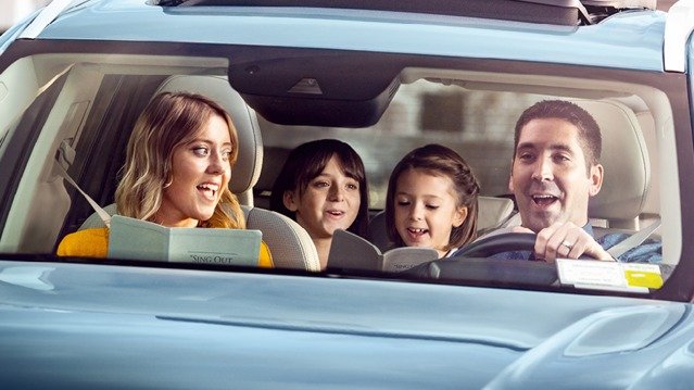 On the way to a meeting, a family practices singing Kingdom songs in the car