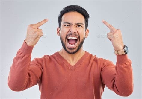 Angry, middle finger and portrait of asian man in studio for rude ...