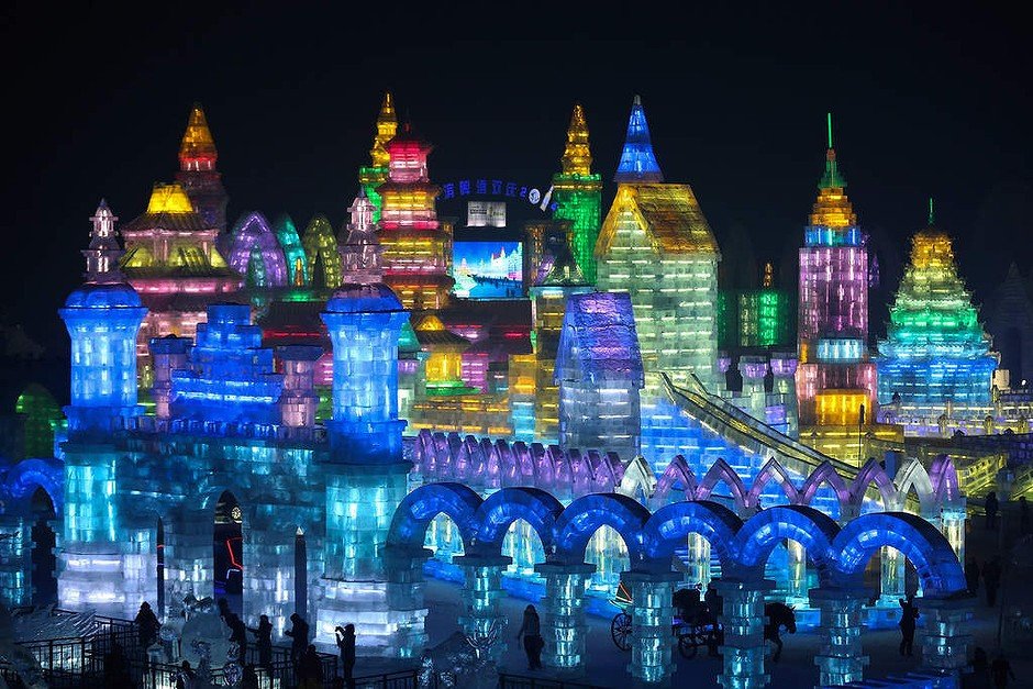 Tourists visit the ice buildings on display at the Grand Ice and Snow World during the 30th Harbin International Ice and Snow Sculpture Festival in Harbin, China.
