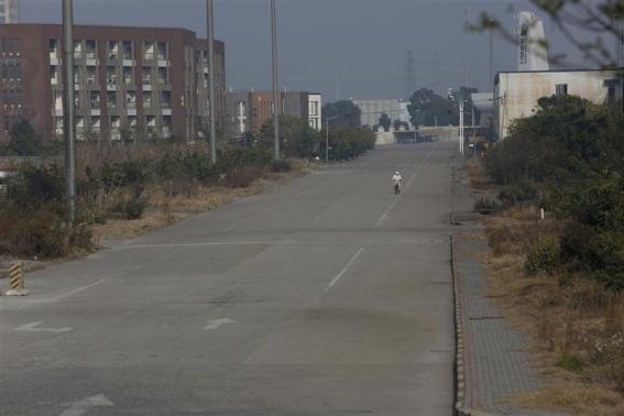A worker rides a bicycle inside of the Rongsheng Heavy Industries shipyard in Nantong, Jiangsu province December 4, 2013. REUTERS-Aly Song
