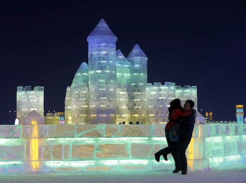 A couple shares an embrace in front of an ice sculpture at the Harbin Ice and Snow Sculpture Festival in the northern city of Harbin, Heilongjiang province, China.