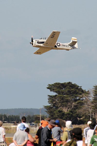 A T-28 Trojan in US Navy colours zooms over the crowd. The aircraft, designed to replace the Harvard, was used in post WW2 training and counter insurgency missions. OH 08-0166-46.jpg. Photo courtesy AC Craig Olsen. 