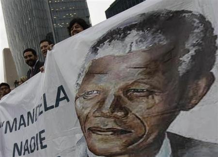 Well-wishers hold a giant banner with an image of former South African President Nelson Mandela during a celebration to mark Mandela's 95th birthday at the Angel de la Independencia monument in Mexico City July 18, 2013. REUTERS/Henry Romero