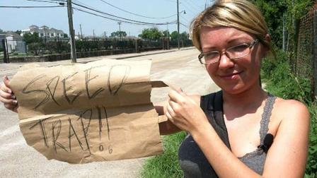 Natalie Plummer holds up a sign she says is like the one she held to warn drivers the day she was arrested near downtown Houston