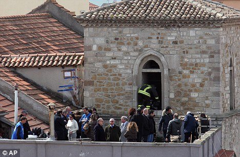 Forensic police inspect the church where the remains of a body were found last week