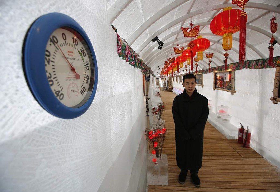 A waiter stands next to a thermometer indicating a  minus 10 degrees reading at the Ice Palace in Shangri-La Hotel in the northern city of Harbin, Heilongjiang province.  The Ice Palace, which is built by ice bricks, is open annually from December to February and attracts visitors during the Harbin Ice and Snow Festival. The temperatures inside the ice building is maintained about minus 10 degrees and it consists of a bar and hot pot restaurant.